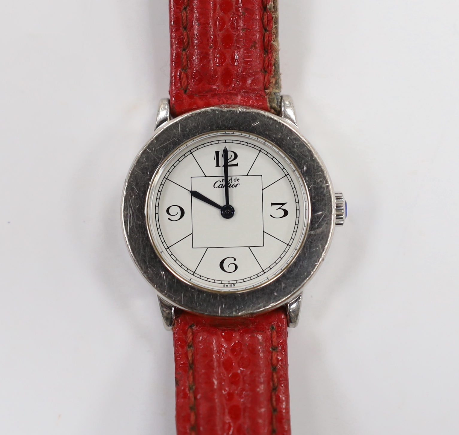 A lady's silver Must de Cartier quartz wrist watch, ref.1806, on a red leather strap, no box or papers, case diameter 27mm.